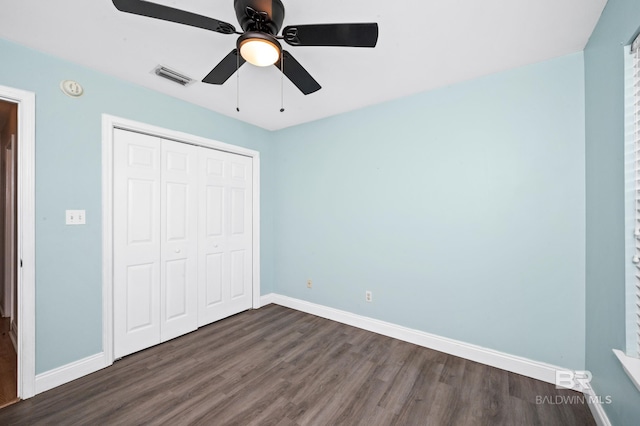 unfurnished bedroom featuring ceiling fan, dark hardwood / wood-style flooring, and a closet