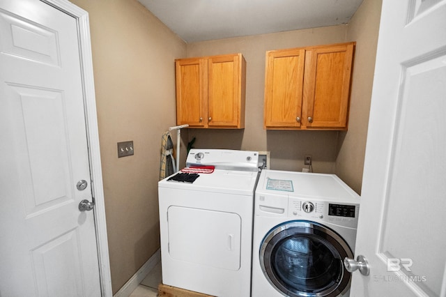 laundry room with washer and clothes dryer and cabinets