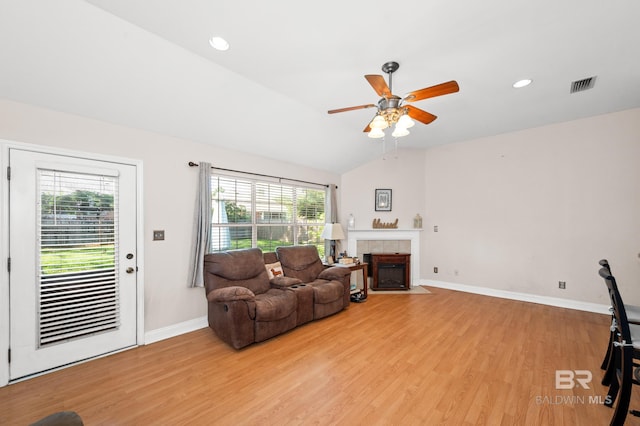 living room featuring a wealth of natural light, light hardwood / wood-style floors, and lofted ceiling