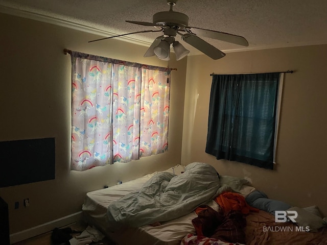 bedroom with ceiling fan, a textured ceiling, and ornamental molding