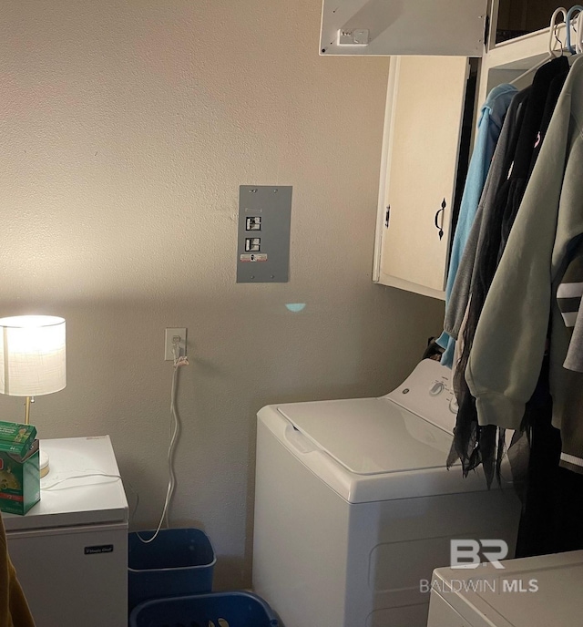 laundry room featuring washing machine and dryer and cabinets