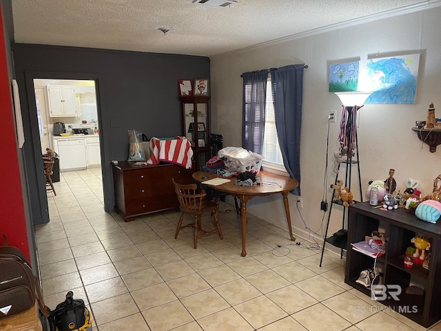 dining area with a textured ceiling, light tile patterned flooring, and washing machine and clothes dryer