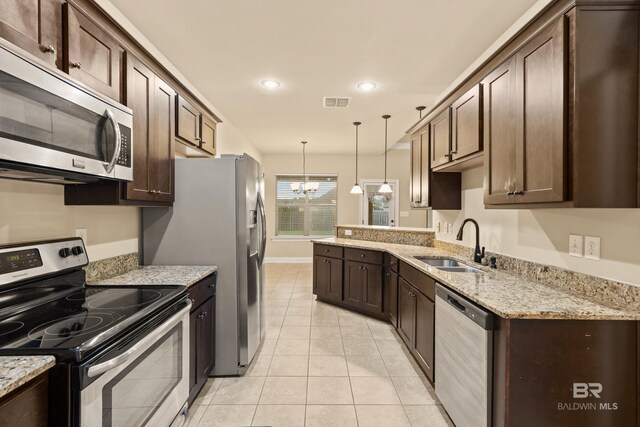 1077 Crown Walk Dr, Foley, AL 36535 - kitchen with an inviting chandelier, a sink, pendant lighting, dark brown cabinets, and appliances with stainless steel finishes