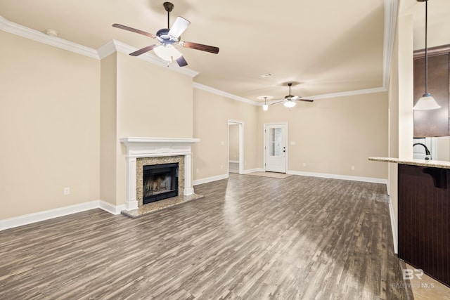 1077 Crown Walk Dr, Foley, AL 36535 - unfurnished living room featuring dark wood-type flooring, ceiling fan, ornamental molding, and a fireplace with raised hearth