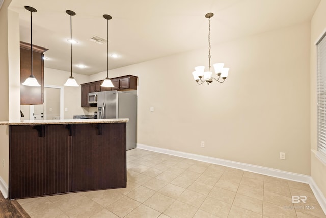 1077 Crown Walk Dr, Foley, AL 36535 - kitchen featuring a notable chandelier, a breakfast bar, a peninsula, visible vents, and dark brown cabinets