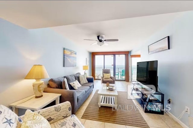 living area with a ceiling fan, baseboards, and light tile patterned floors