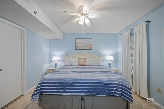 bedroom with a ceiling fan, light tile patterned flooring, and a textured ceiling