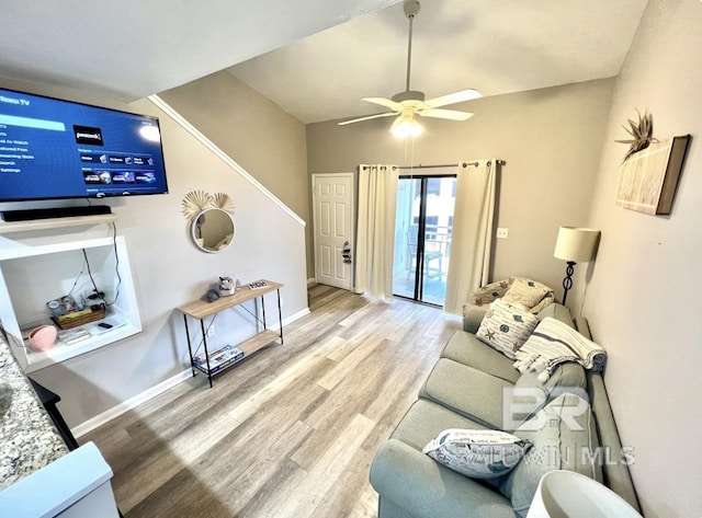 living room with hardwood / wood-style floors, ceiling fan, and lofted ceiling