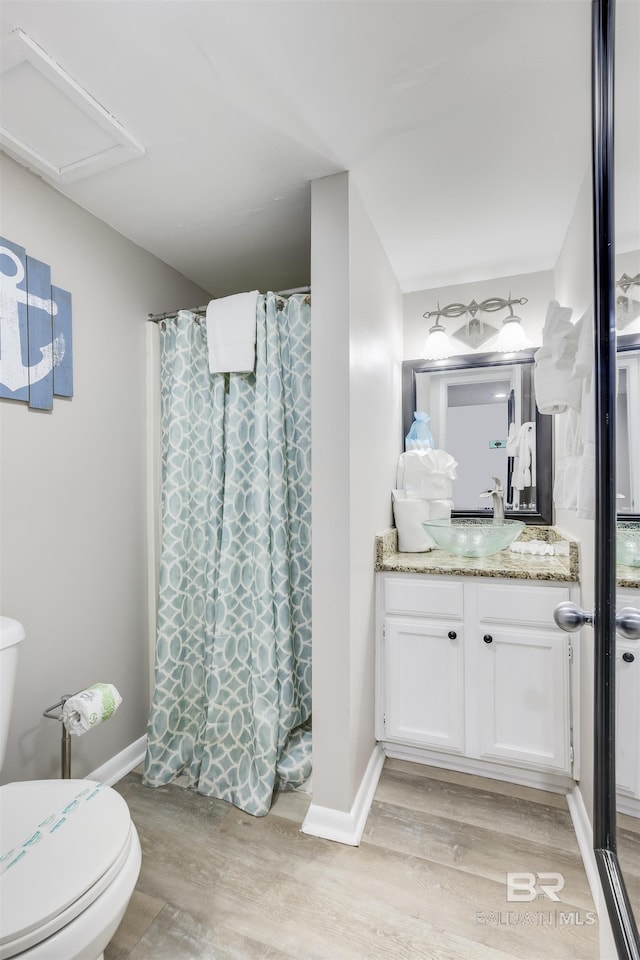 bathroom with a shower with curtain, toilet, vanity, and hardwood / wood-style flooring