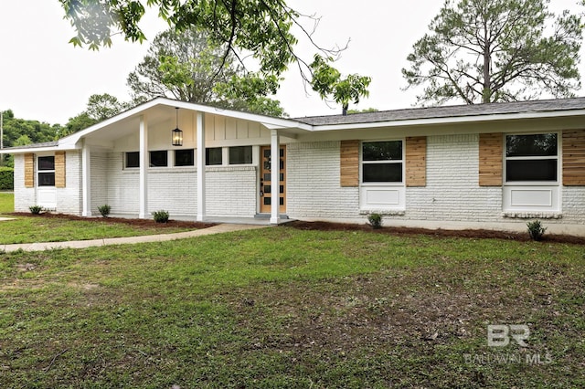 5922 Sunnyside Dr, Mobile, AL 36619 - view of front facade with brick siding, a front lawn, and board and batten siding