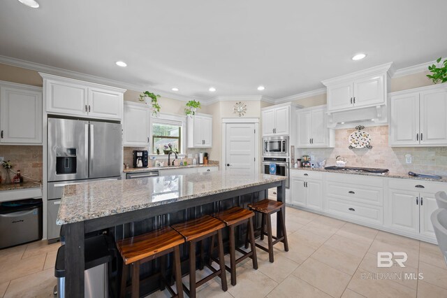 32035 Bobwhite Rd, Spanish Fort, AL 36527 - kitchen with appliances with stainless steel finishes, under cabinet range hood, a kitchen bar, white cabinets, and a sink