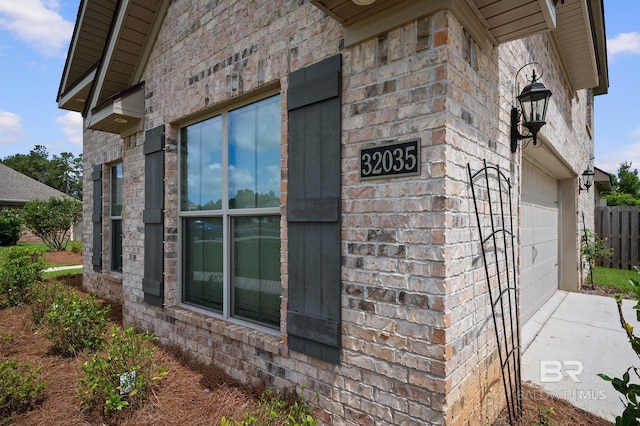 32035 Bobwhite Rd, Spanish Fort, AL 36527 - view of home's exterior featuring brick siding, a garage, concrete driveway, and fence
