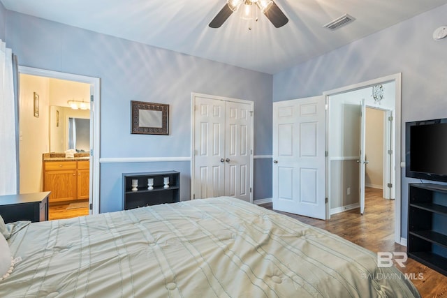 bedroom with a closet, ensuite bath, light wood-type flooring, and ceiling fan