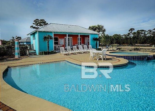 view of pool with a patio and an in ground hot tub