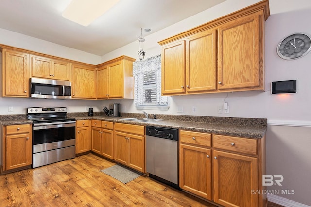 kitchen featuring sink, appliances with stainless steel finishes, and light wood-type flooring