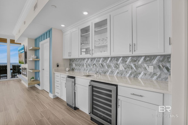 bar with a sink, wine cooler, backsplash, and wet bar