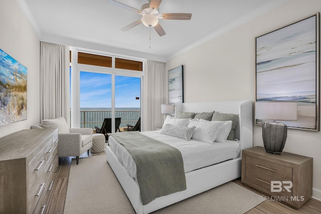 bedroom with a water view, light wood-type flooring, crown molding, and ceiling fan