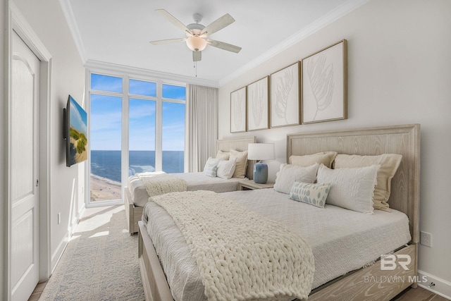 carpeted bedroom featuring baseboards, ornamental molding, and ceiling fan