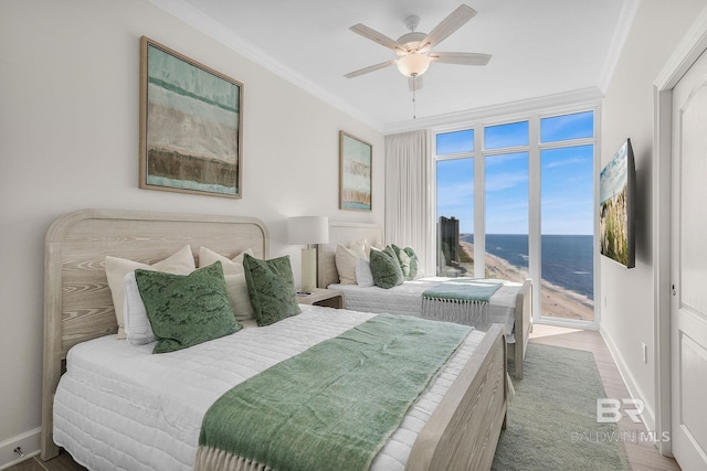 bedroom with baseboards, crown molding, wood finished floors, and ceiling fan