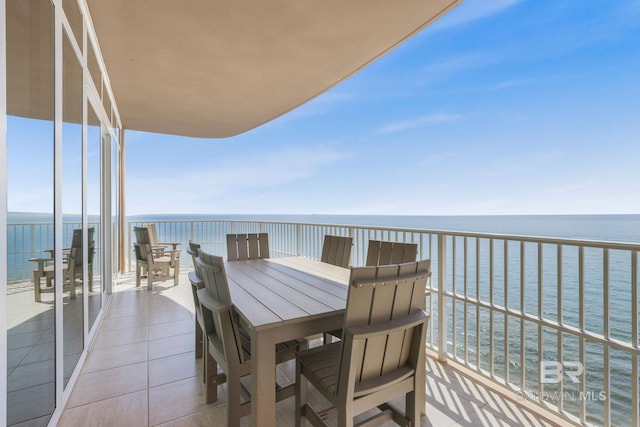 balcony featuring outdoor dining area and a water view