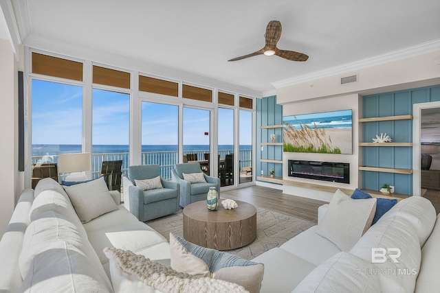 living room featuring visible vents, crown molding, and wood finished floors
