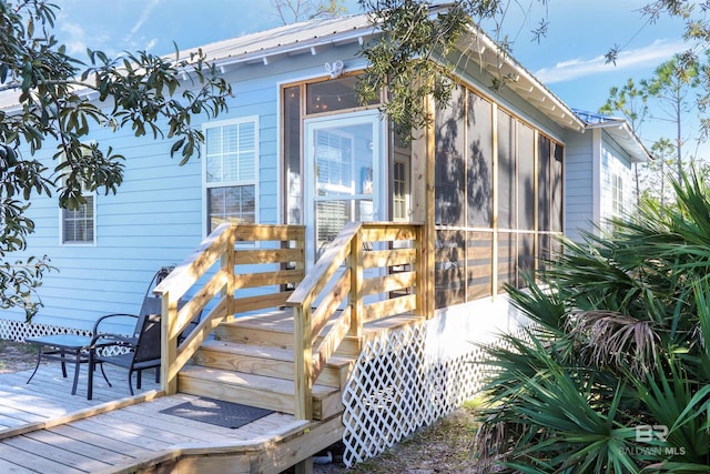 doorway to property with metal roof and a deck