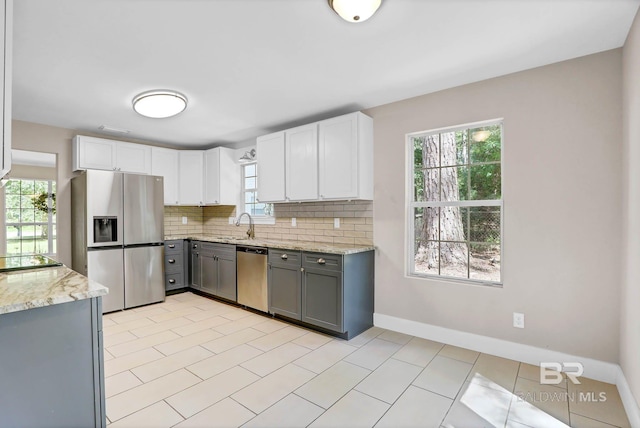 106 Gordon Cir, Daphne, AL 36526 - kitchen with appliances with stainless steel finishes, gray cabinets, decorative backsplash, light stone counters, and white cabinetry