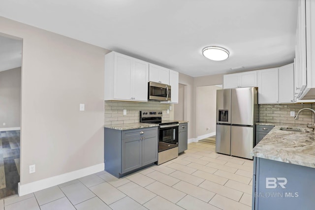 106 Gordon Cir, Daphne, AL 36526 - kitchen with appliances with stainless steel finishes, tasteful backsplash, light stone countertops, and white cabinets