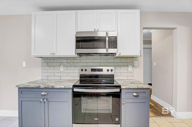 106 Gordon Cir, Daphne, AL 36526 - kitchen with stainless steel microwave, electric range, tasteful backsplash, and light stone countertops