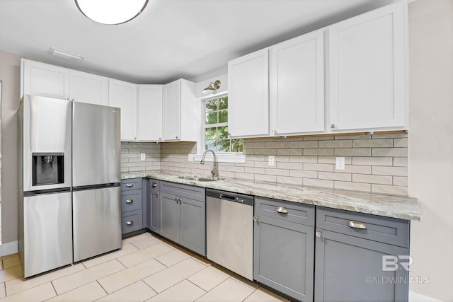 106 Gordon Cir, Daphne, AL 36526 - kitchen with appliances with stainless steel finishes, gray cabinets, decorative backsplash, white cabinets, and light stone countertops