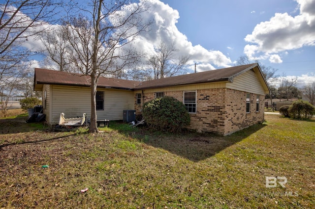 view of side of home featuring central AC unit and a lawn