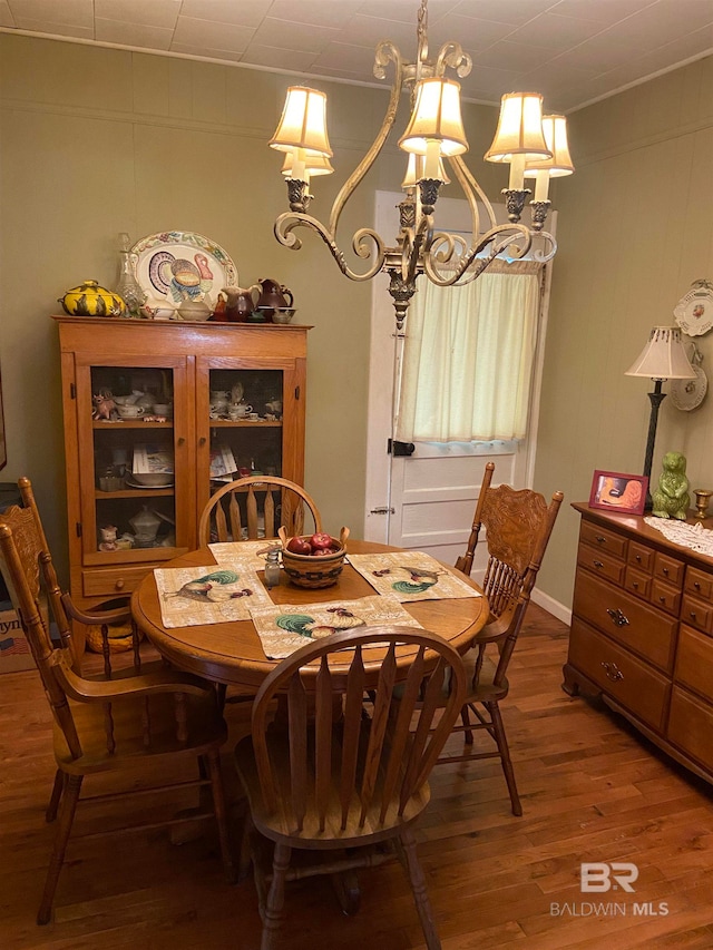 dining space with a notable chandelier and hardwood / wood-style floors