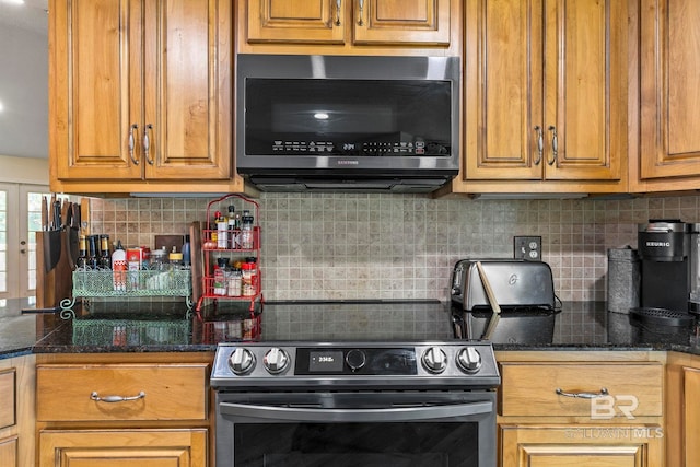 kitchen featuring tasteful backsplash, dark stone counters, and appliances with stainless steel finishes