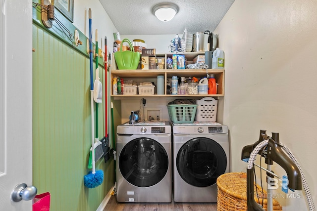 washroom featuring hardwood / wood-style flooring, washing machine and dryer, and a textured ceiling