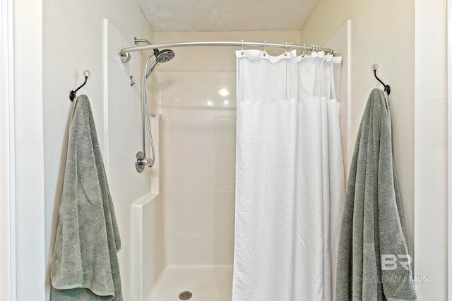 bathroom featuring a shower with curtain and a textured ceiling