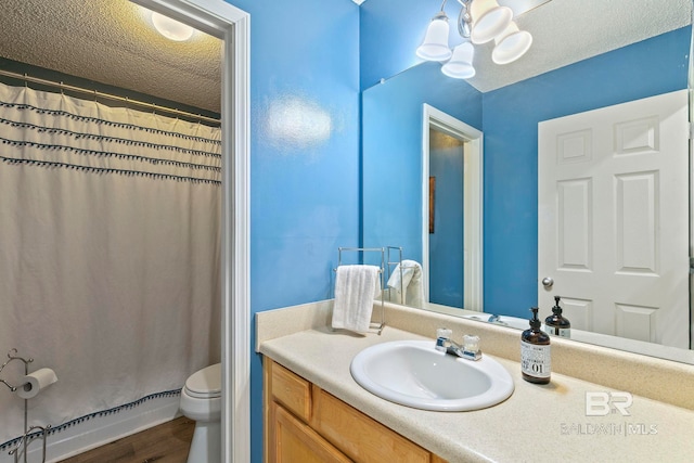 bathroom featuring baseboard heating, a textured ceiling, toilet, vanity, and hardwood / wood-style flooring