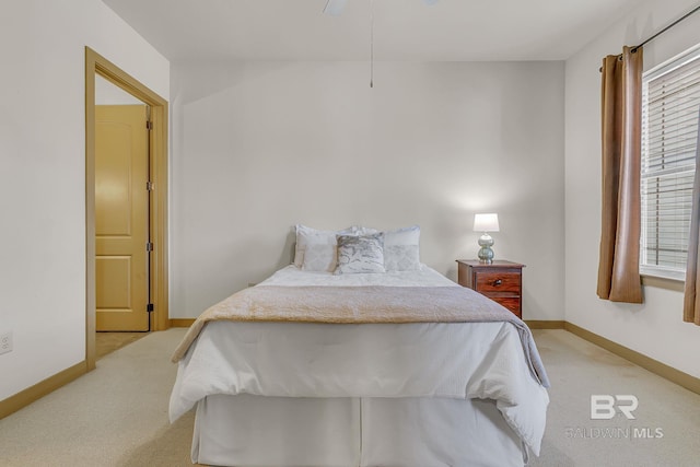 bedroom with light carpet, multiple windows, and baseboards