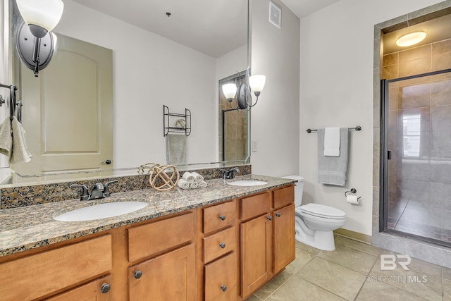 bathroom featuring double vanity, a stall shower, a sink, and toilet