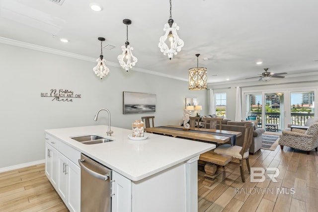 kitchen with sink, white cabinetry, a kitchen island with sink, hanging light fixtures, and stainless steel dishwasher