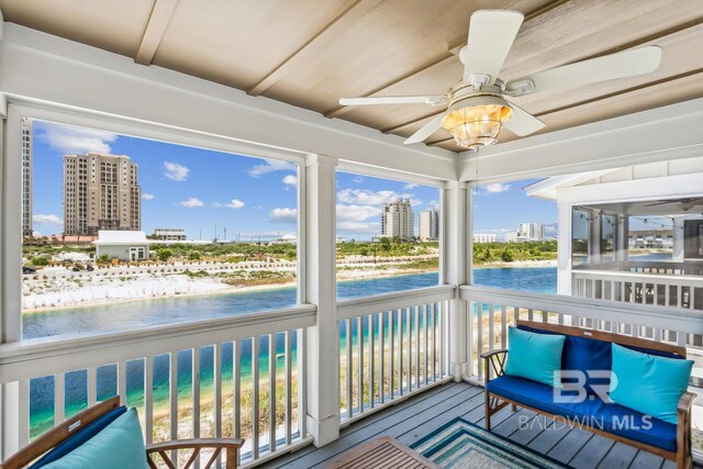 sunroom with ceiling fan, a healthy amount of sunlight, and a water view