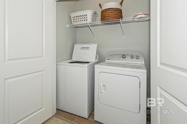 clothes washing area featuring separate washer and dryer and light hardwood / wood-style flooring