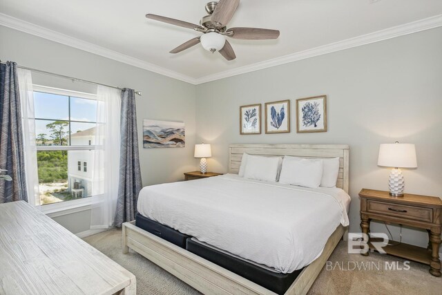 bedroom featuring light colored carpet, ornamental molding, and ceiling fan