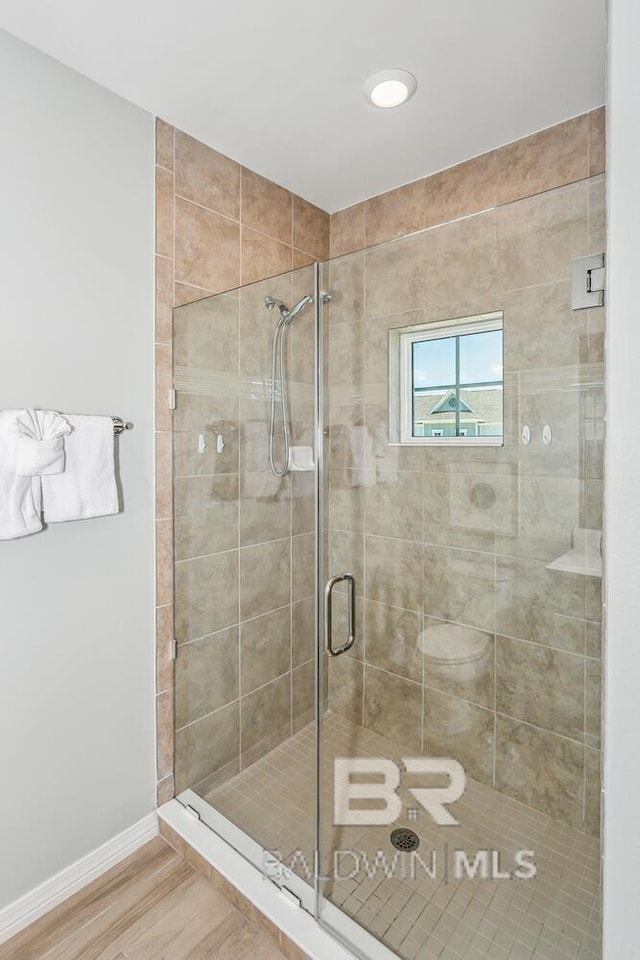 bathroom featuring hardwood / wood-style flooring and walk in shower