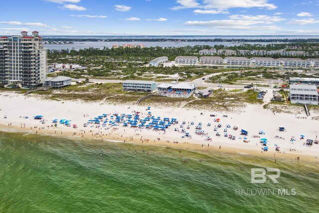 birds eye view of property featuring a water view and a beach view