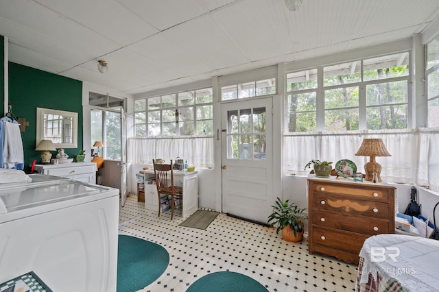 sunroom / solarium featuring washing machine and clothes dryer and a healthy amount of sunlight