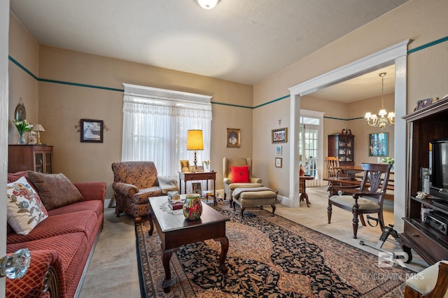 living room with light carpet, a healthy amount of sunlight, and a chandelier