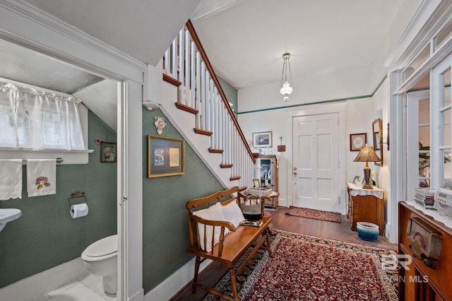 entryway with dark hardwood / wood-style floors and vaulted ceiling