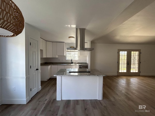 kitchen with a kitchen island, island range hood, white cabinetry, sink, and french doors