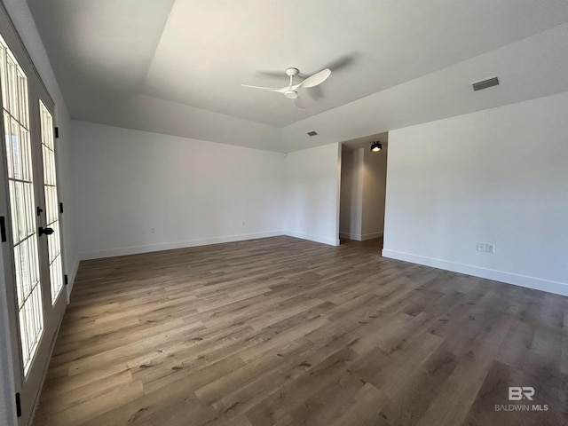 spare room featuring dark hardwood / wood-style flooring, a tray ceiling, french doors, and ceiling fan