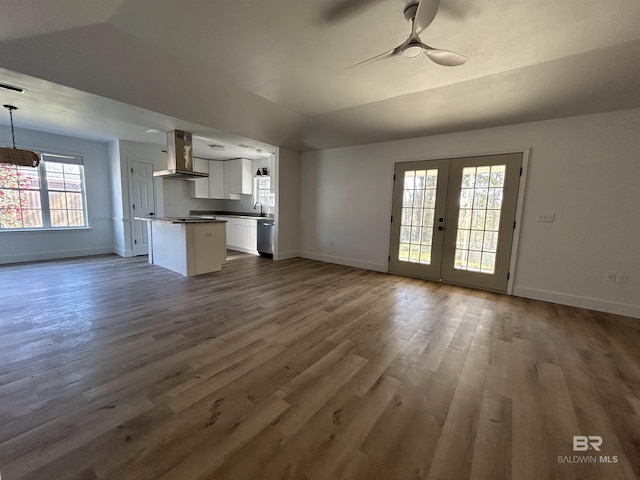 unfurnished living room featuring lofted ceiling, dark wood-type flooring, ceiling fan, and french doors